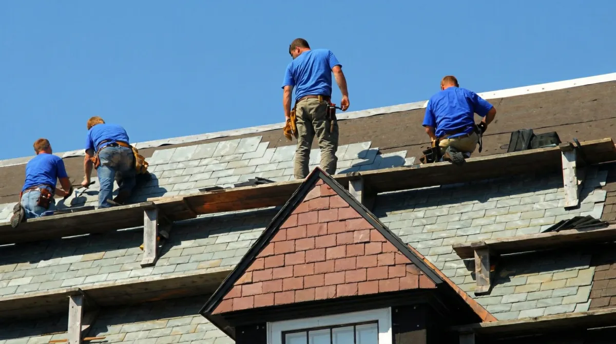 Roof replacement in progress with a team of professional contractors installing new shingles on a residential home in Pueblo, CO